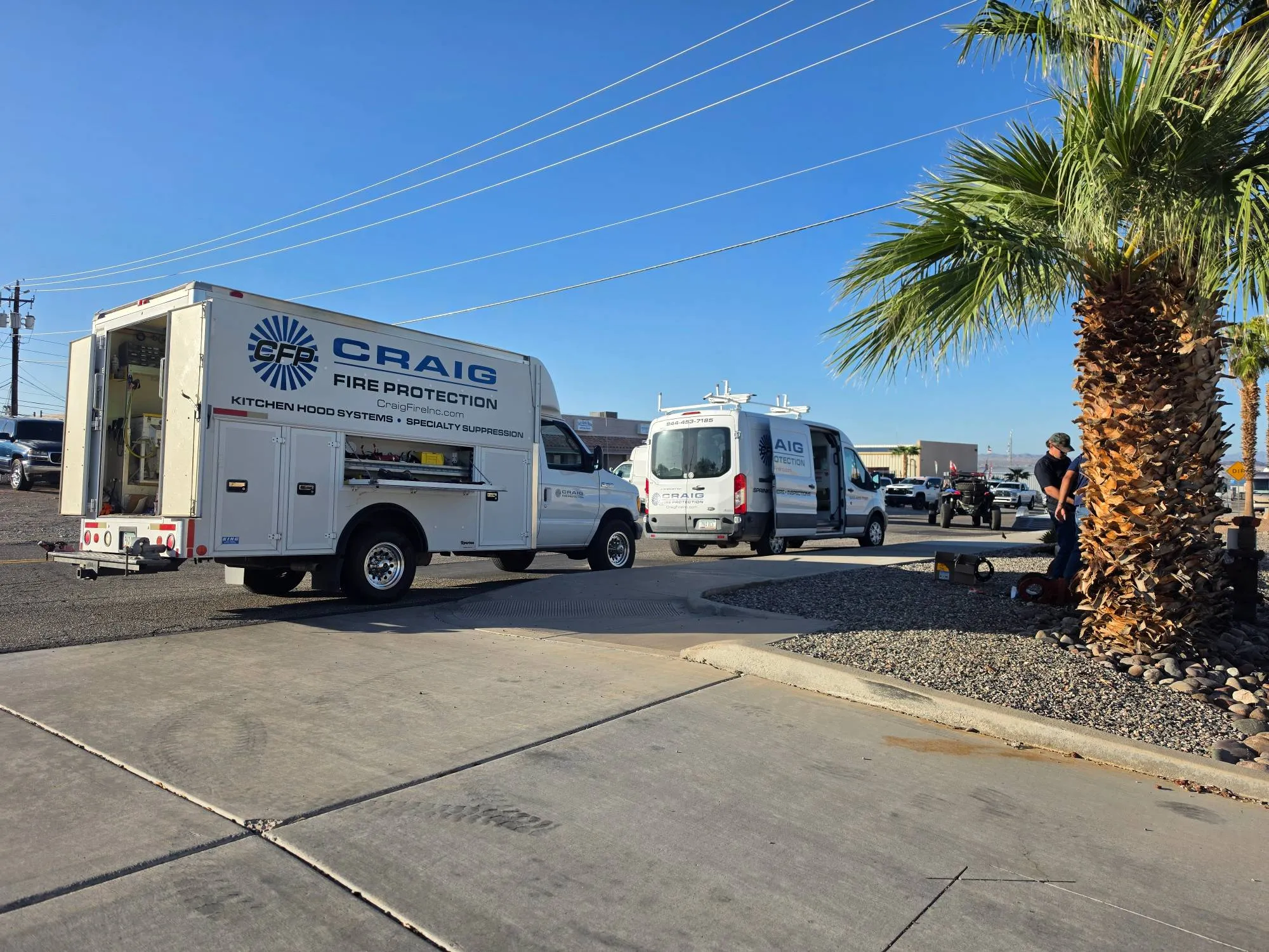 Craig Fire Protection service truck and van on site, with technicians working nearby