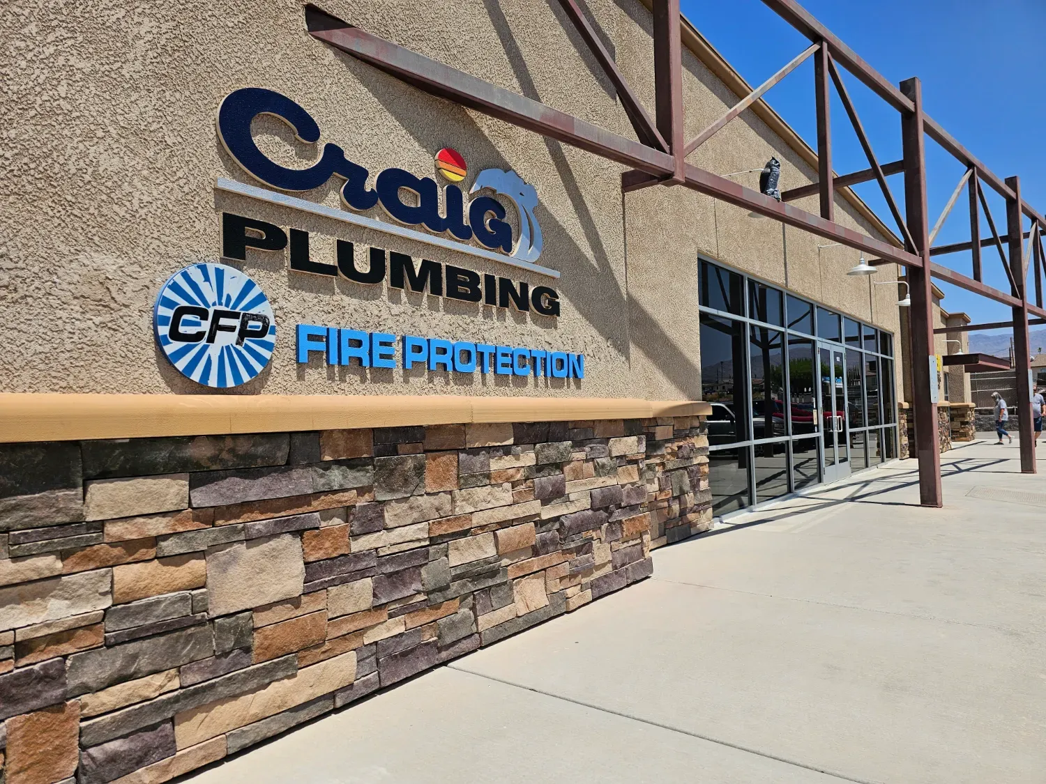 The Craig Plumbing and Craig Fire Protection office building, with company signs above a stone-faced storefront
